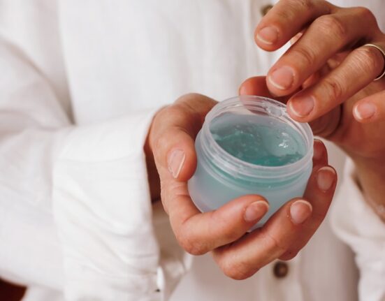 person holding blue plastic container